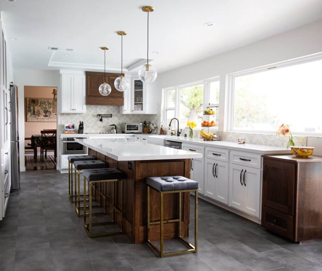 White kitchen remodel with a wood island and pendant lighting