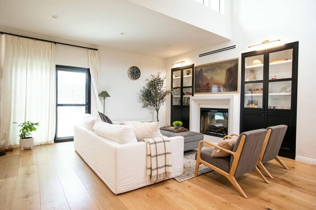 Living room with fireplace, built-in cabinets and wood floors at Zelzah Avenue