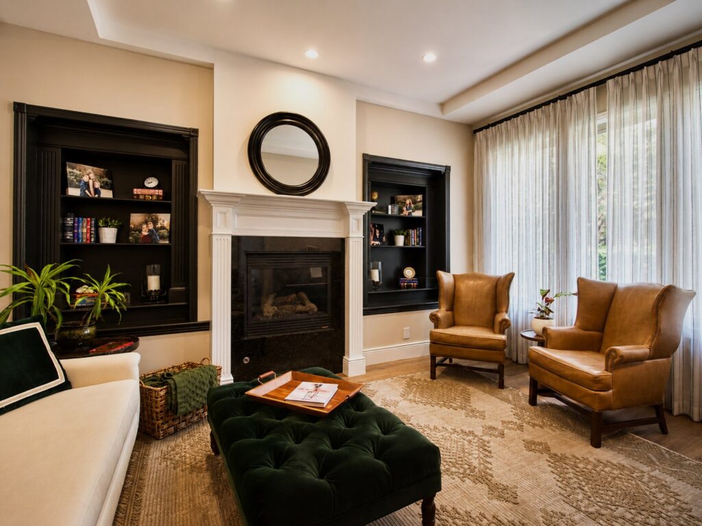 Sitting room with fireplace, built-in shelving and leather chairs in the Loch Lomond home renovation