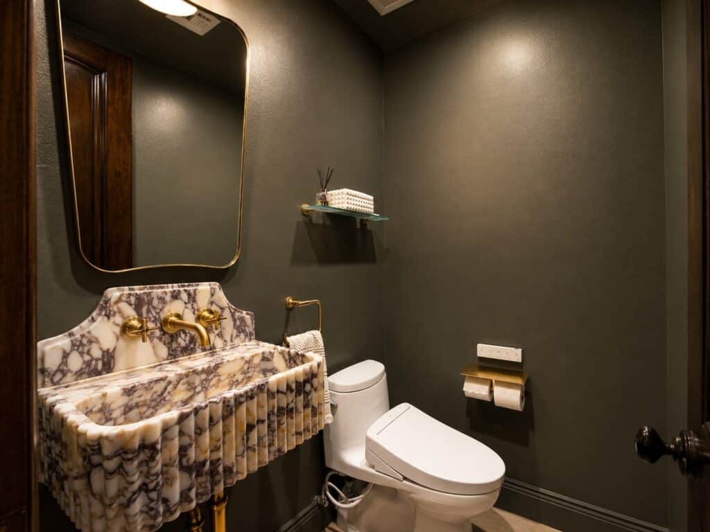 Powder room with patterned stone vanity and dark walls in the Loch Lomond home renovation