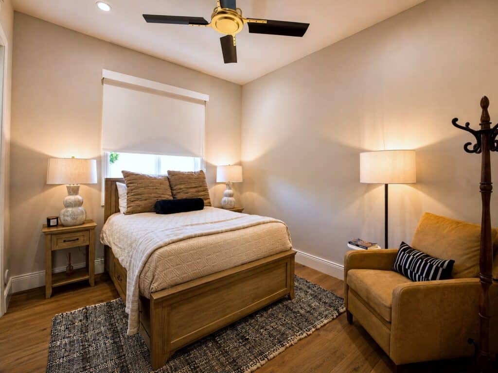 Guest bedroom with neutral finishes and ceiling fan in the Loch Lomond home renovation