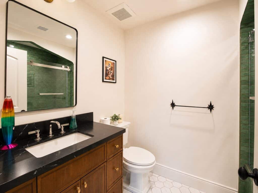 Bathroom vanity with wood cabinetry and green tile in the Loch Lomond home renovation